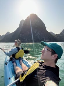 Steven in a kayak below a limestone peak