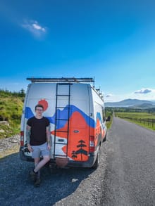 Steven standing by a campervan on a country road